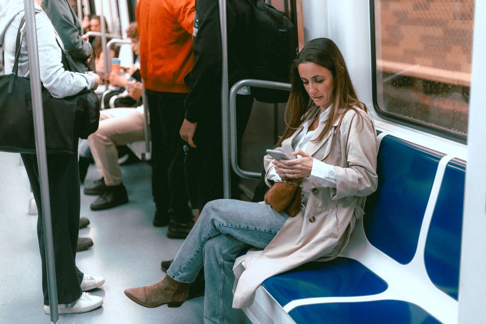 A woman in her forties at a cafe window, reading a message on her phone